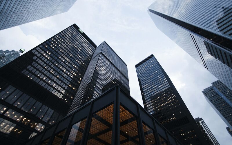 Glass office towers viewed from street level against the sky