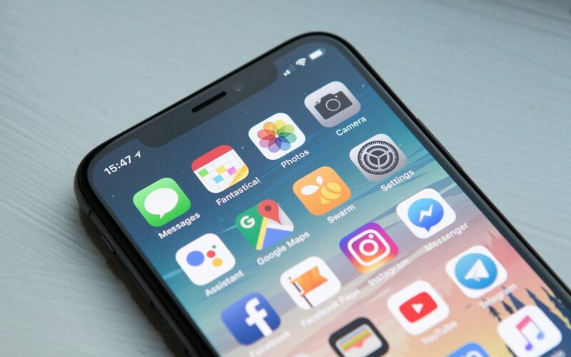 A modern smartphone lying face up on a dark desk surface