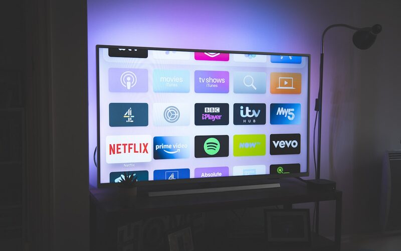 A wall-mounted television displaying a grid of streaming service apps